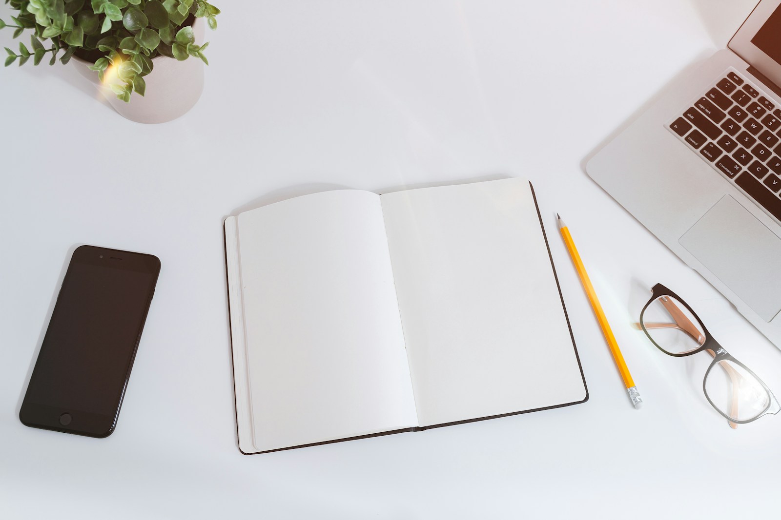 A workspace with a laptop, phone and planning notes